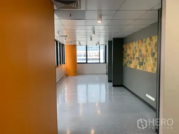 办公空间 出租在Bang Rak, Bangkok - 明亮办公区，橙色立柱、射灯与几何墙面装饰。