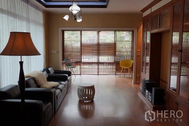 บ้าน ให้เช่าในSuan Luang, Bangkok - ห้องนั่งเล่นสว่าง พื้นไม้ โซฟาหนัง ม่านไม้ไผ่ และตู้บิวท์อิน