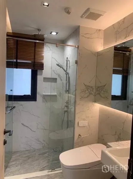 คอนโด ให้เช่าในWatthana, Bangkok - ห้องน้ำพร้อมฉากกั้นกระจก โถสุขภัณฑ์ และผนังลายหินอ่อน