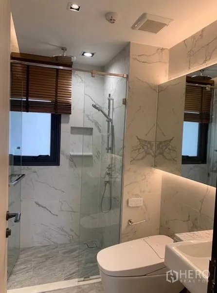 คอนโด ให้เช่าในWatthana, Bangkok - ห้องน้ำพร้อมฉากกั้นกระจก โถสุขภัณฑ์ และผนังลายหินอ่อน