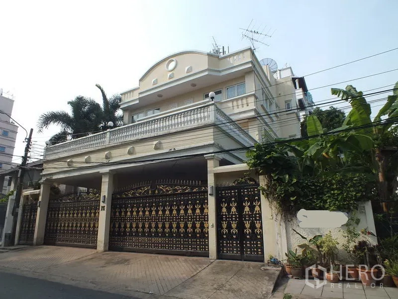 Detached House for rent in Bang Rak, Bangkok - Three-storey detached house exterior with ornate wrought-iron gate, balconies and palm landscaping.