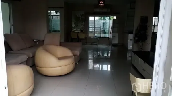 บ้าน ให้เช่าในLat Krabang, Bangkok - ห้องนั่งเล่นแบบโอเพ่นสเปซ พื้นกระเบื้องเงา ชุดโซฟาสีเบจและหน้าต่างบานใหญ่