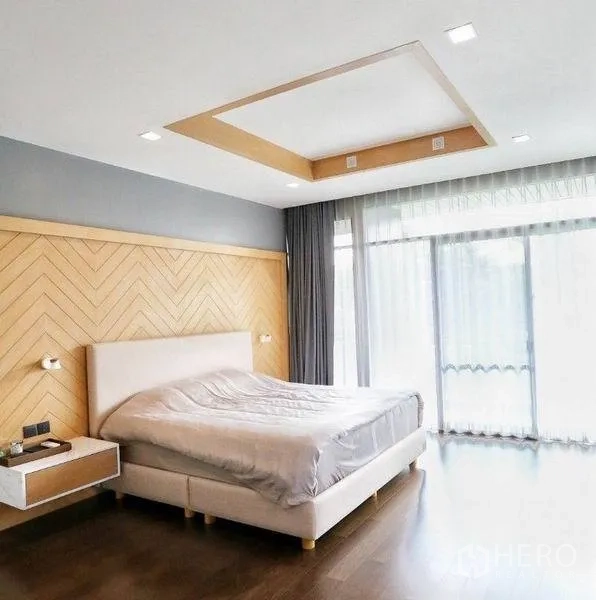 Detached House for rent or sale in Bang Kapi, Bangkok - Spacious master bedroom with herringbone wood headboard, tray ceiling and full-height windows.