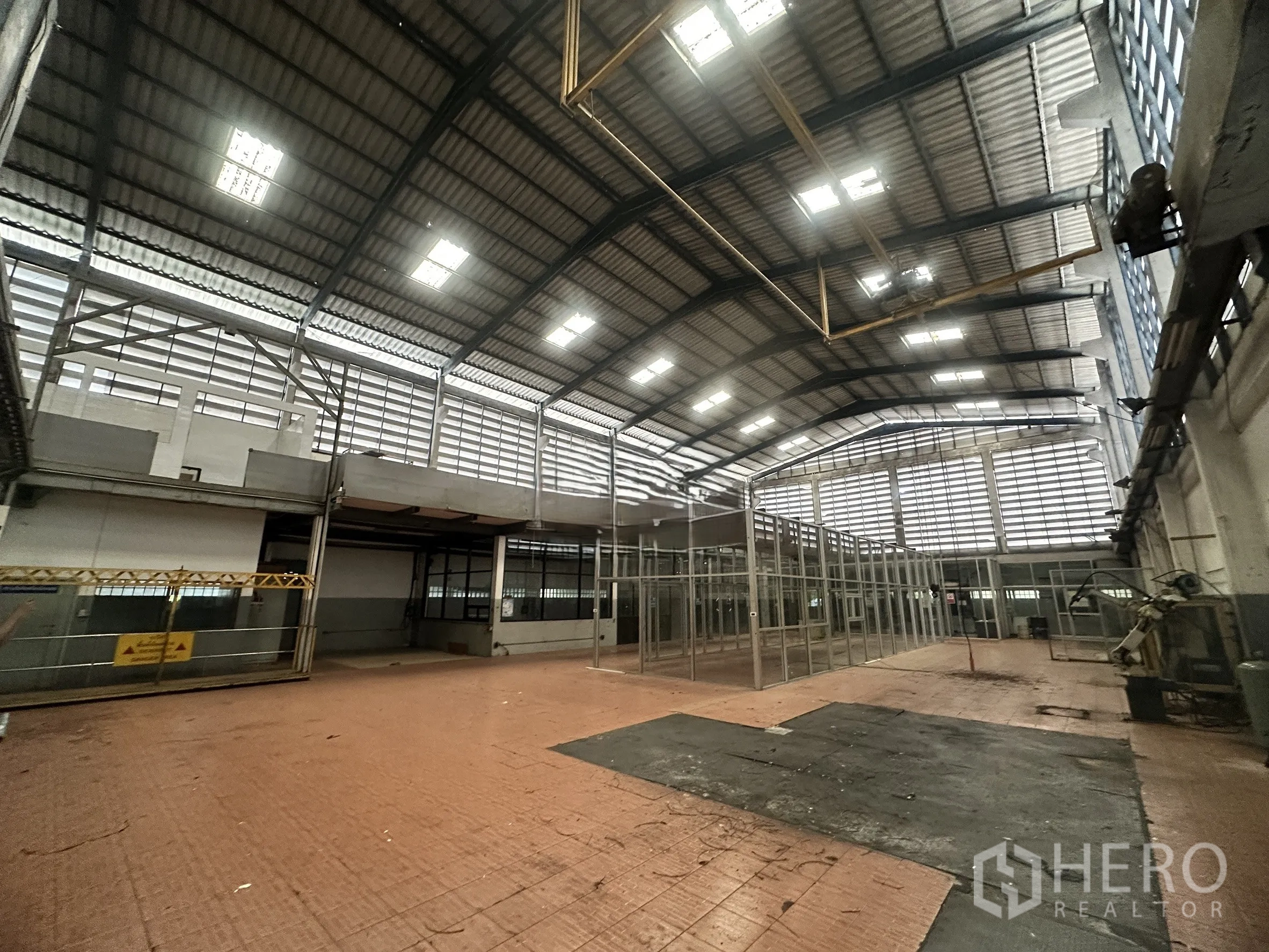 Factory for sale in Bang Bua Thong, Nonthaburi - Wide manufacturing space with high ceiling and louvered side panels for airflow.