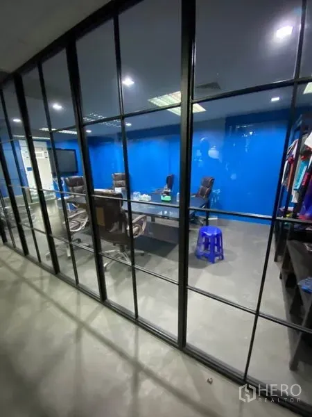 Office Space for rent in Khlong Toei, Bangkok - Glass-walled meeting room featuring a blue accent wall, conference table and executive chairs.