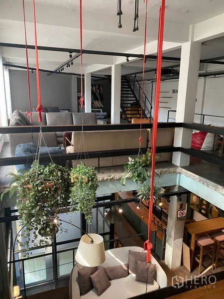 零售空间 出租在Bang Na, Bangkok - 夹层视角，悬挂绿植与下方休息区。