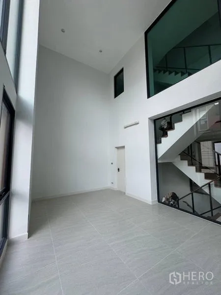 Townhouse for rent - Double-height living space with tall ceilings and glazed stair enclosure.