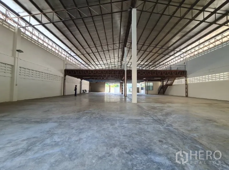 Warehouse for rent in Khlong Toei, Bangkok - Expansive warehouse interior with high steel-truss roof and concrete floor.