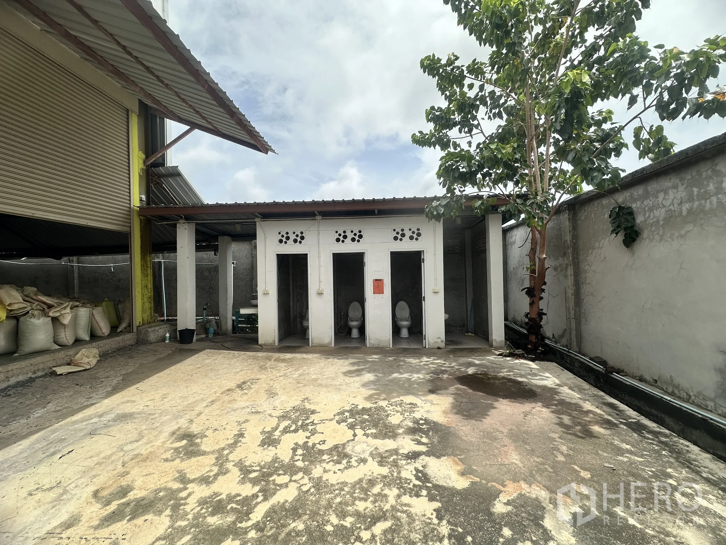 Warehouse for rent in Mueang Samut Prakan, Samut Prakan - Outdoor restroom block adjacent to the warehouse with paved yard.