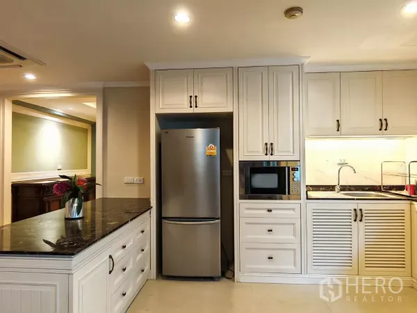 คอนโด ให้เช่าในPathum Wan, Bangkok - ห้องครัวพร้อมตู้สีครีม เคาน์เตอร์หินสีดำ ตู้เย็นสแตนเลสและไมโครเวฟ