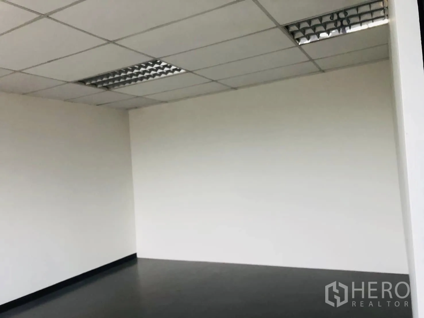 Office Space for rent in Lat Phrao, Bangkok - Clean white corner wall and tiled floor in an unfurnished office.