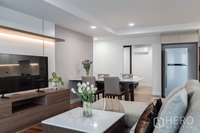 Apartment for rent - Living area detail with TV console, four-seat dining table and decor flowers.
