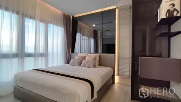 Condominium for rent in Bang Kho Laem, Bangkok - Master bedroom with king bed, mirrored headboard wall and large windows with blackout curtains.