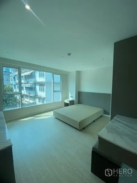 อพาร์ทเมนท์ ให้เช่าในWatthana, Bangkok - ห้องนอนที่สอง หน้าต่างมุมบานใหญ่ วิวเมือง โต๊ะข้างเตียง และพื้นไม้ลามิเนตสีอ่อน