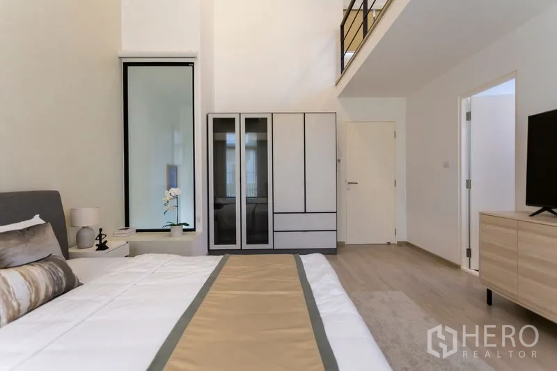 Townhouse for rent in Bang Phli, Samut Prakan - Master suite view with wardrobe, high ceilings and mezzanine railing.