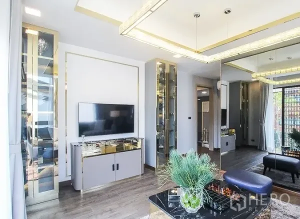 Detached House for rent or sale in Prawet, Bangkok - Bright lounge with TV, mirrored wall and built-in display cabinets.
