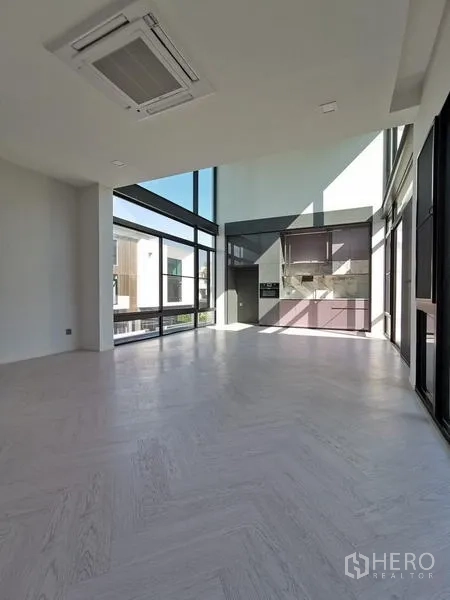 Detached House for rent or sale in Saphan Sung, Bangkok - Open-plan living and dining area with soaring ceiling, panoramic windows and built-in cabinetry.