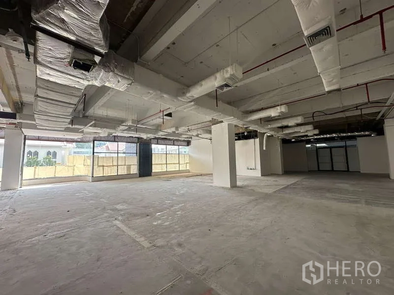 办公空间 出租 - 开放式毛坯办公区，层高充裕，外露风管与落地窗。