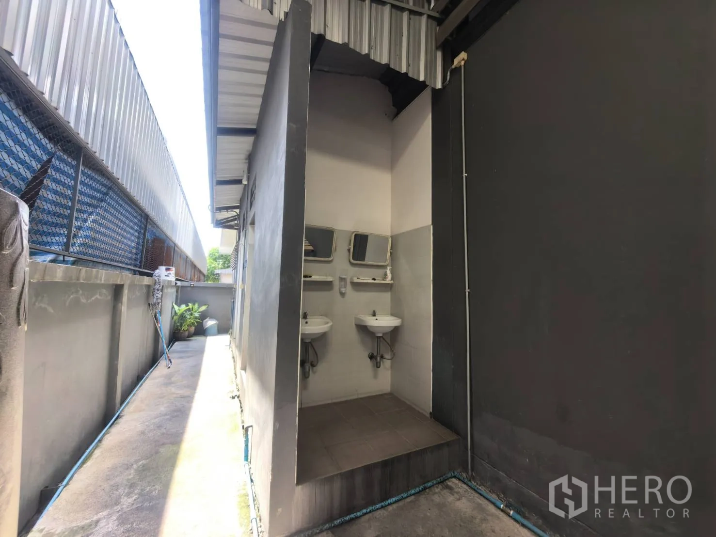 Warehouse for rent in Bang Sao Thong, Samut Prakan - Wash basin nook along an exterior corridor under a roof.