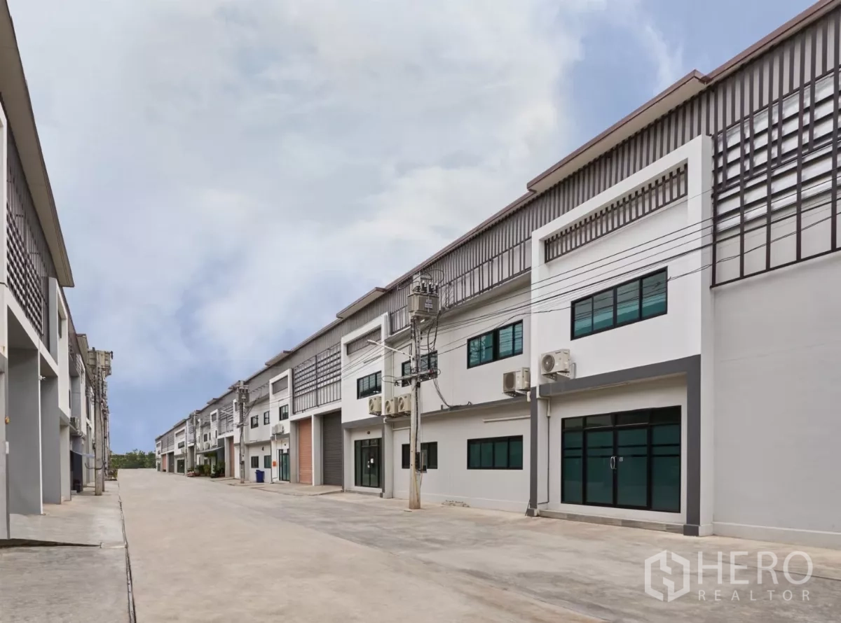 โรงงาน ให้เช่าในMueang Samut Sakhon, Samut Sakhon - ถนนภายในกว้าง คั่นระหว่างสองแถวโรงงาน พร้อมเสาและสายไฟฟ้า.