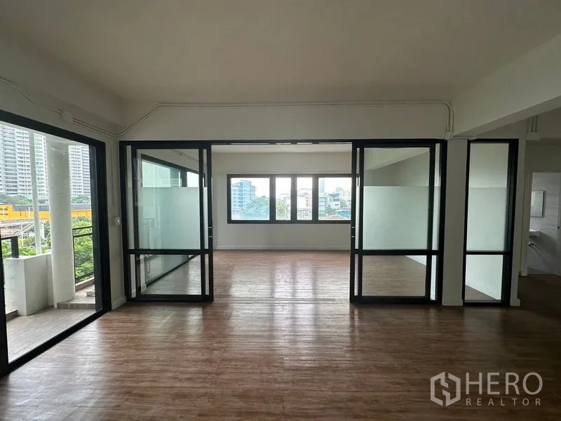 办公空间 出租在Sathon, Bangkok - 中央房间以落地玻璃分隔，两侧为开放区，窗外可见城市景色。