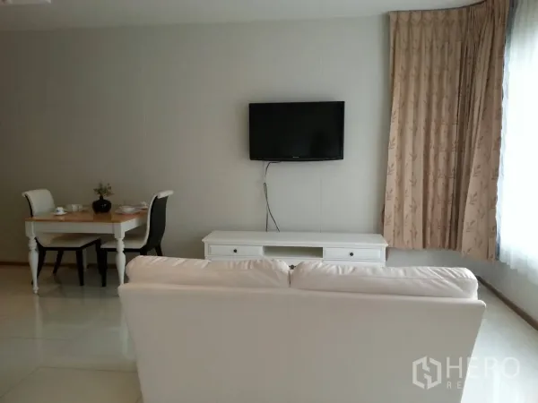 คอนโด ให้เช่าในKhlong Toei, Bangkok - วิวห้องนั่งเล่นพร้อมตู้วางทีวีและโต๊ะทานข้าวสองที่นั่ง ถัดจากหน้าต่างเต็มบาน