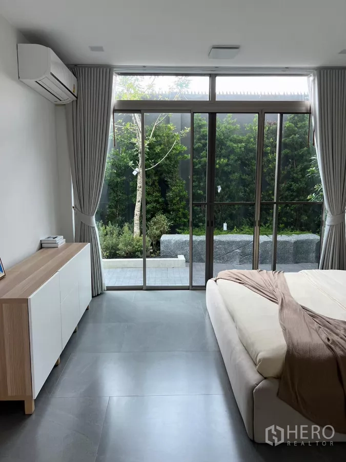 独立式住宅 出租在Saphan Sung, Bangkok - 一层卧室，推拉玻璃门直通私家花园。