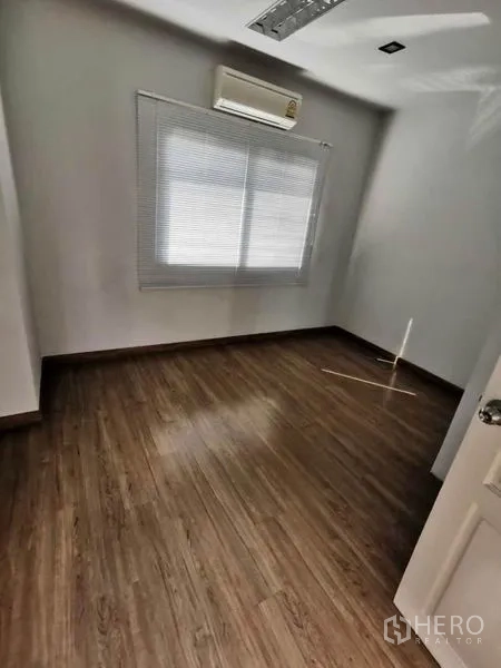 Home Office for rent in Prawet, Bangkok - Private room or bedroom with window blinds, wood floor, and wall-mounted air conditioner