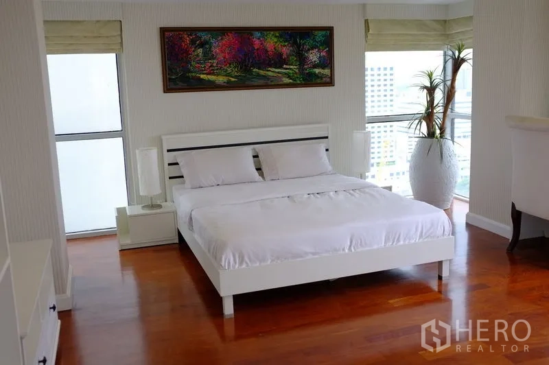 公寓 出租在Watthana, Bangkok - 转角卧室，白色床、床头装饰画与观景窗。