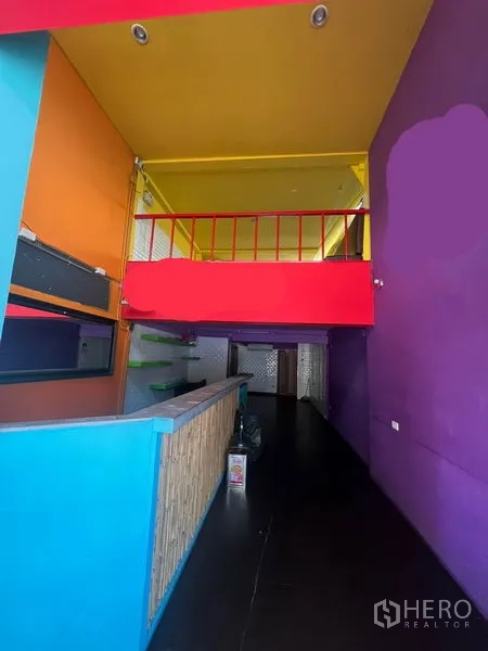 อาคารพาณิชย์ ให้เช่าในKhlong Toei, Bangkok - พื้นที่โอเพ่นสเปซมองไปยังชั้นลอยราวสีแดงและเคาน์เตอร์บริการ ผนังสีสด