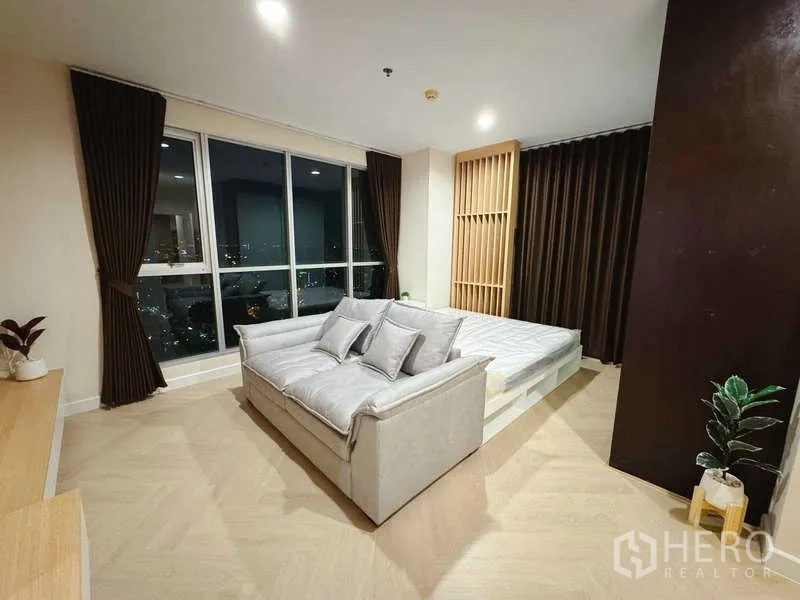 คอนโด ให้เช่าในChatuchak, Bangkok - ห้องนอนใหญ่พร้อมหน้าต่างเต็มบาน วิวเมือง เตียงแพลตฟอร์ม โซฟา และผ้าม่านทึบ