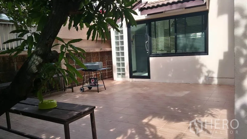 独立式住宅 出租 - 宽敞的瓷砖露台，连接玻璃推拉门，树荫环绕。