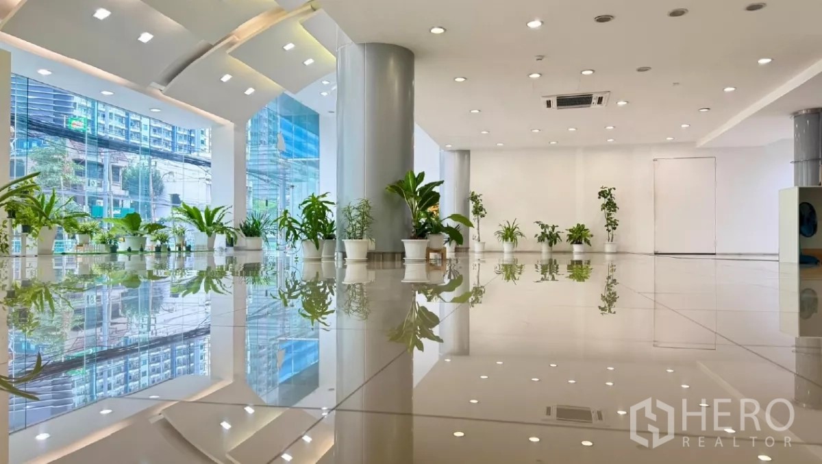零售空间 出租在Huai Khwang, Bangkok - 明亮的零售展厅，落地玻璃、高挑空与亮面地砖，可见繁华街景。