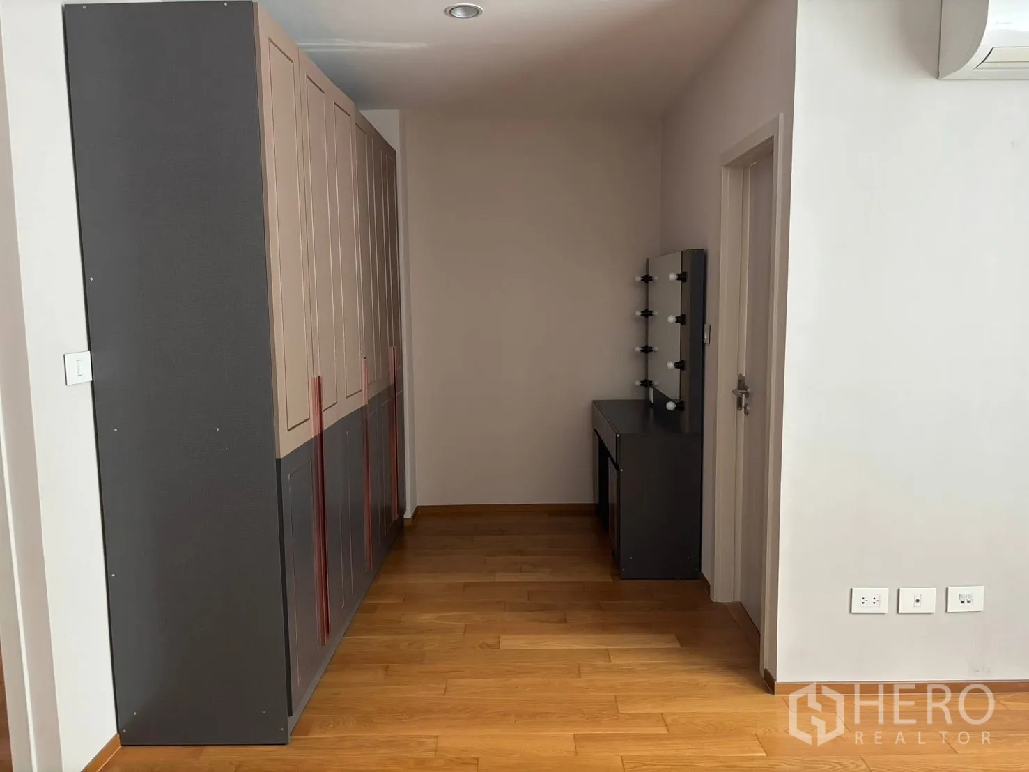 Townhouse for rent in Saphan Sung, Bangkok - Built-in wardrobe and dressing table area in a wood-floored room.