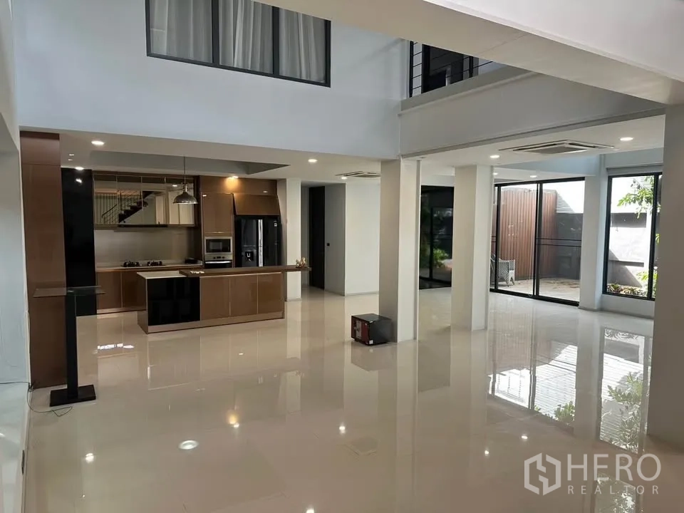 Detached House for sale in Watthana, Bangkok - Open-plan living area with an island kitchen and floor-to-ceiling windows.