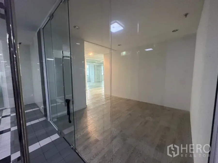 办公空间 出租在Din Daeng, Bangkok - 玻璃围合的小房间，旁接条纹地砖公共区。