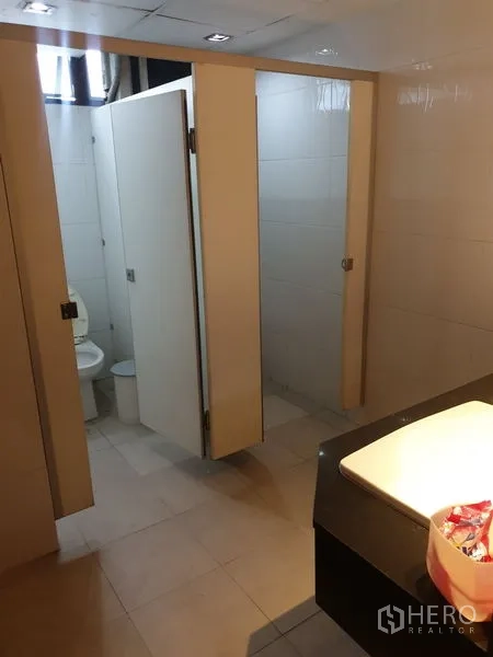 Office Space for rent - Modern restrooms with tiled floors, private stalls and a vanity sink.