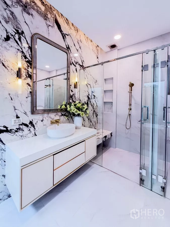 Detached House for rent in Saphan Sung, Bangkok - Vanity with vessel sink beside glass shower in marble bathroom.