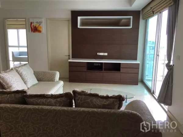 คอนโด ให้เช่าหรือขายในKhlong Toei, Bangkok - ห้องนั่งเล่นสว่าง โซฟาลาย ผนังบิลท์อินไม้ และประตูกระจกออกระเบียง