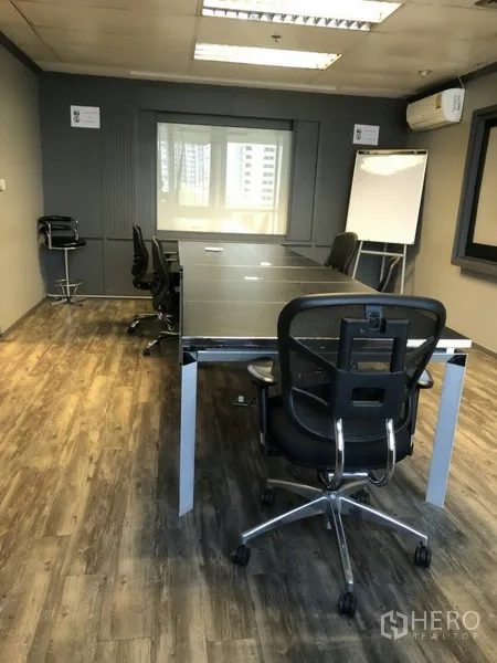 Office Space for rent in Khlong Toei, Bangkok - Private meeting room with long conference table, mesh chairs, whiteboard and wall‑mounted air conditioner.