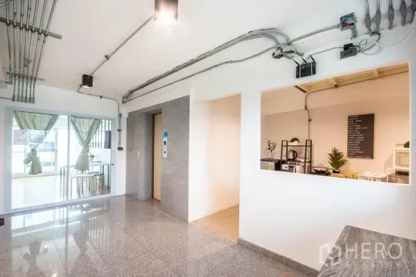 带办公室的家 出租在Phaya Thai, Bangkok - 明亮大厅设电梯与外露管线，玻璃门通向会客区。