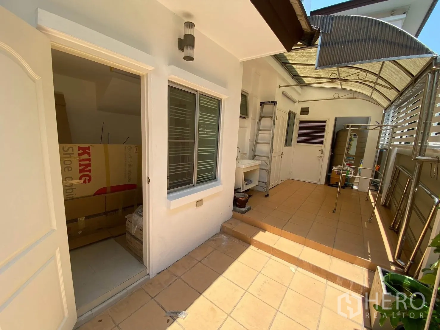 Detached House for rent in Mueang Samut Prakan, Samut Prakan - Covered side utility area with sink, storage doors, and tiled floor.