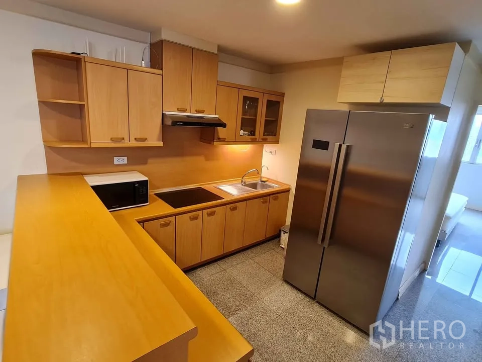 Condominium for rent in Khlong Toei, Bangkok - Laundry room with washing machine and wraparound windows.