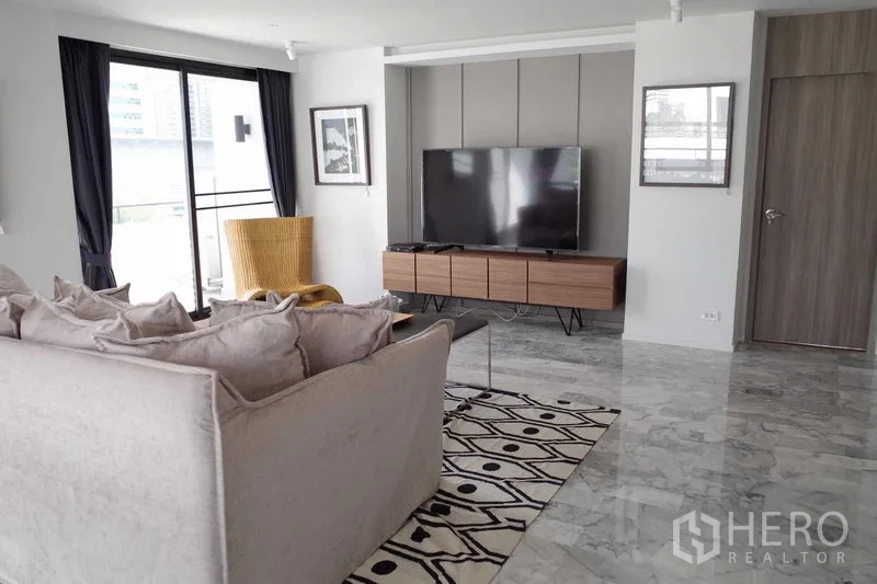 คอนโด ให้เช่าในWatthana, Bangkok - ห้องนั่งเล่นกว้าง โซฟานุ่ม ประตูบานเลื่อนออกสู่ระเบียง และชั้นวางทีวี