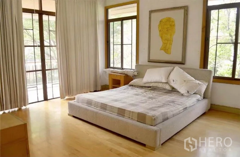 Detached House for rent or sale in Bang Phli, Samut Prakan - Primary bedroom with large windows, balcony access and light wood floors.