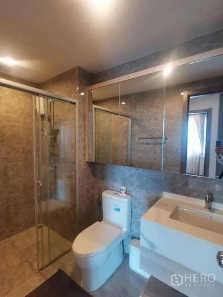 公寓 出售在Huai Khwang, Bangkok - 现代浴室，玻璃淋浴间、大镜柜与石纹墙面。