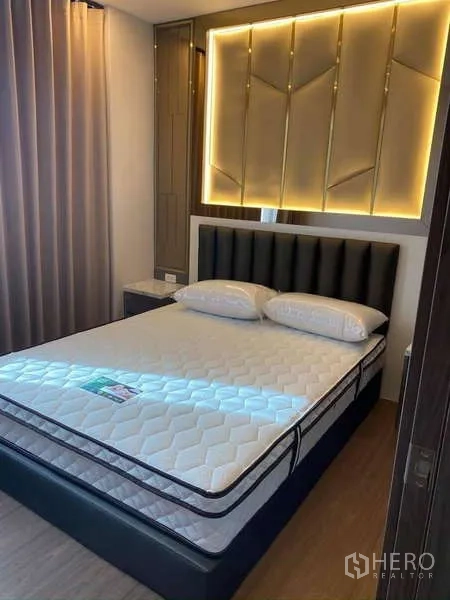 公寓 出售在Huai Khwang, Bangkok - 卧室配软包床头、床头柜与背光装饰墙。