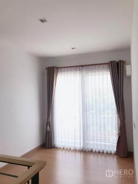 บ้าน ขายในSuan Luang, Bangkok - ห้องสว่างพร้อมประตูกระจกบานเลื่อนไปยังระเบียงและผ้าม่านยาว