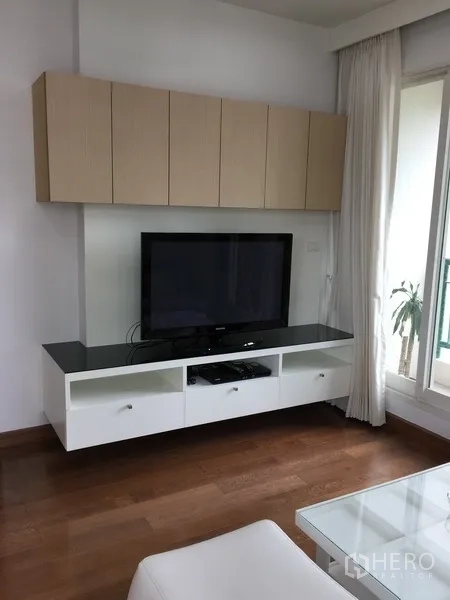 Condominium for rent in Pathum Wan, Bangkok - Living room TV cabinet with wall storage beside sliding glass doors to the balcony.