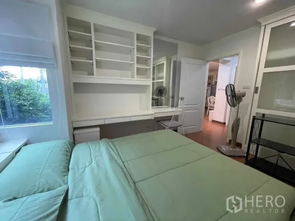 คอนโด ให้เช่า - มุมอื่นของห้องนอน แสดงโต๊ะทำงาน ชั้นวาง และหน้าต่างวิวต้นไม้